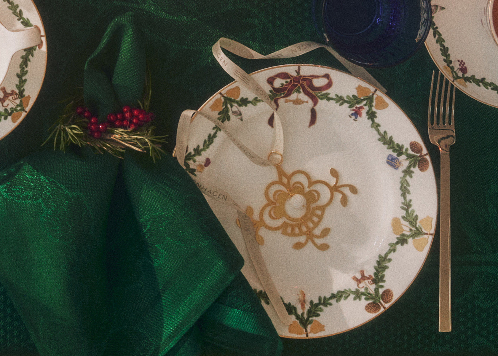 A Christmas gold ornament on a Star Fluted Christmas plate